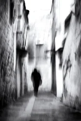 Una figura sfocata in un vicolo