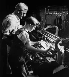 Un maestro addestra un giovane apprendista nella maglieria meccanica, Lyle e Scott, Hawick