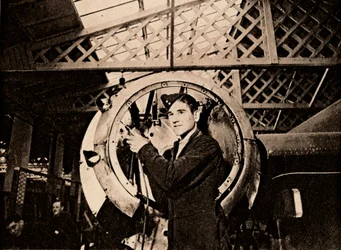 Un operaio metalmeccanico con trapano automatico che smonta un carter motore, 1940