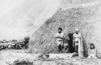 Una vecchia che batte il tapa davanti a una casa di erba pili, Kalaupapa, Hawaii, XIX secolo