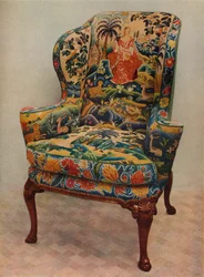 Una poltrona imbottita con ali, struttura in noce intagliato e rivestimento originale in seta ricamata, c17