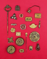Collezione di gioielli anglosassoni e celtici tra cui montature in bronzo dorato, fibbie a piattino e cruciformi e un pendente merovingio, dal I al VII secolo d.C.