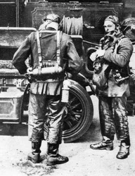 Vigili del fuoco che indossano elmetti antifumo, Farringdon Street rubber works, Londra, 1926-1927
