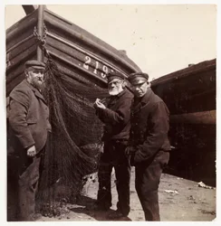 Pescatori in piedi vicino a una rete, circa 1905