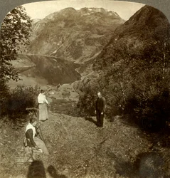 Fienagione su una mensola di montagna sopra il villaggio di Marok e il fiordo Geirangerfjord, Norvegia