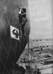Regolazioni alla rete di un pallone prima di attaccare il cestino, c1935 c1937