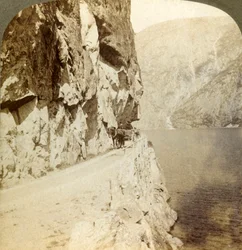 Sentiero scavato nelle scogliere torreggianti per una strada intorno al lago Oifjords, Norvegia