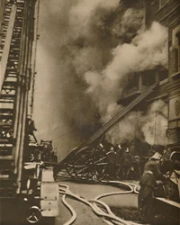 Domare un incendio in una stretta strada cittadina, c. 1935