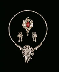 Gioielli Art Deco: spilla pendente in diamanti baguette, spilla a rotolo in rubino cabochon e diamanti, orecchini pendenti in diamanti
