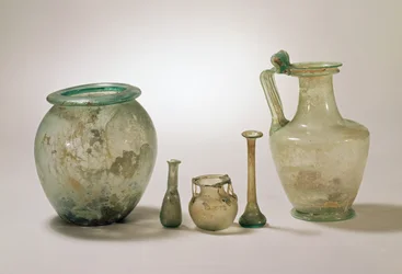 Collezione di vetri romani: urna cineraria, vetri funerari e brocca, I-IV secolo