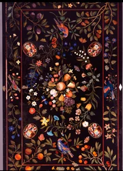Un piano di tavolo fiorentino in pietra dura intarsiato con vari marmi e lapislazzuli centrato da una composizione di frutta