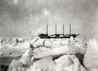 Una nave a quattro alberi che naviga tra gli iceberg