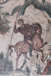 Dettaglio del mosaico della piccola caccia. Un cacciatore sta per trafiggere una lepre. III - IV secolo. Villa Romana del Casale, Sicilia. Sito UNESCO.