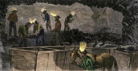 Minatori che scavano la miniera e caricano il carbone in piccoli carri trainati da muli in Pennsylvania. Incisione colorata del 1860