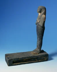 Figura di Ptah-Sokar-Osiride con parrucca tripartita e braccia incrociate su piedistallo rettangolare con compartimento contenente una sezione di papiro, Egiziano, XXI-XXII Dinastia