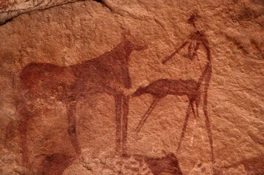 Arte rupestre, preistoria: Pittura rupestre di una mucca, vitello e personaggio (arciere) in un rifugio ornato, nel massiccio di Uweinat, Egitto. Periodo da 8000 a 3000 anni a.C.