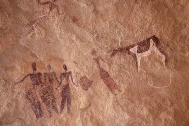 Arte rupestre, Preistoria: Pittura rupestre di un gruppo di personaggi e una mucca bicolore con grandi corna in un rifugio ornato, nel massiccio di Uweinat, Egitto. (Periodo da 8000 a 3000 anni a.C.). Fotografia