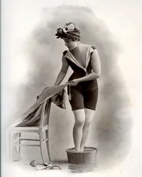 Giovane donna in costume da bagno (dalla Belle Époque) che fa un pediluvio, circa 1900 (foto b/n)