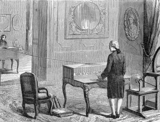 Georges Lesage, inventore del primo telegrafo elettronico davanti a un prototipo. 1774. Incisione del XIX secolo
