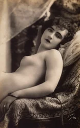 Una giovane donna che posa nuda su un divano