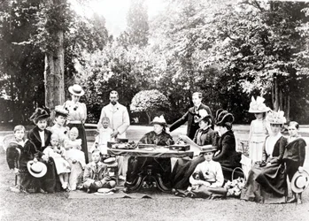 Membri della famiglia reale britannica tra cui Re Giorgio V, Re Edoardo VIII intorno alla Regina Vittoria a una festa in giardino. Fotografia tra il 1895 e il 1901