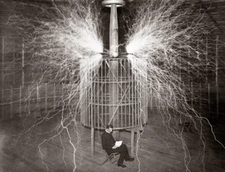 Nikola Tesla seduto nel suo laboratorio di Colorado Springs con il suo "Trasmettitore Amplificante"