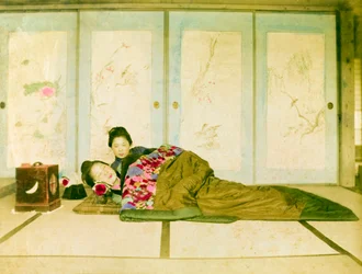 Sdraiati su un futon. Due donne giapponesi sdraiate su un futon tradizionale posto sul pavimento. Giappone, circa 1910.