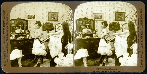 Carta stereoscopica che raffigura una donna che viene allacciata in un corsetto, c.1900