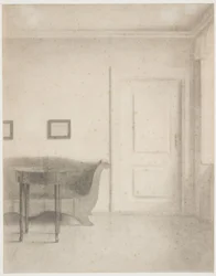 Interno con divano e piccolo tavolo, a destra una porta