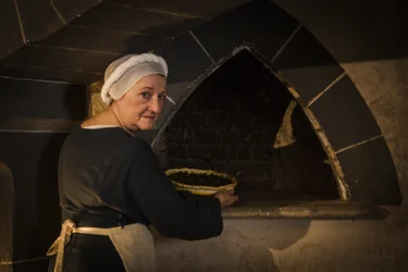 Rievocazione storica: Cameriera che mette una torta nel forno della cucina del castello