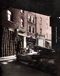 Cesti di frutta ammucchiati contro le case al Borough Market, Londra, 1926-1927