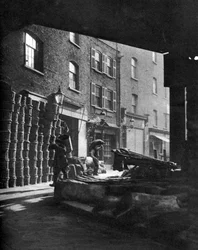 Cestini di frutta ammucchiati contro le case al Borough Market, Londra (1926-1927)