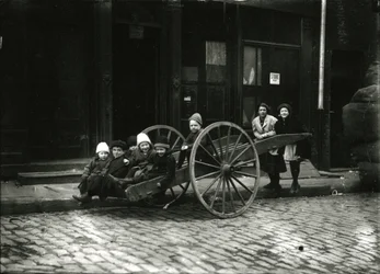 Gruppo di bambini in carrozza, con ragazza e donna in piedi dietro, c.1910-21