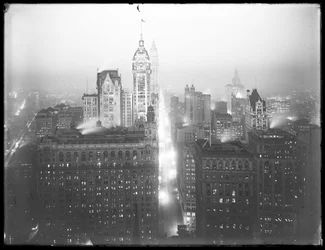 Vista notturna nebbiosa di Lower Manhattan verso nord, con il Singer Building, il Woolworth Building e il Municipal Building visibili, c.1913