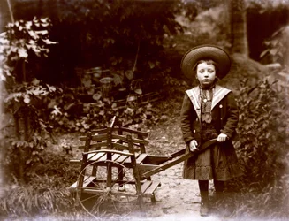 Ragazza con carretto in un giardino, inizio XX secolo (foto b/n)