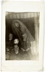 Fenomeno paranormale: ritratto di tre persone anziane, lo spirito di una donna che appare dietro di loro, verso 1920